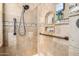 Tiled shower featuring a rainfall shower head, built-in niches, and grab bars at 8176 E Sweet Bush Ln, Gold Canyon, AZ 85118