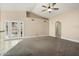 Spacious living room featuring tile floors, neutral paint, ceiling fan, and access to hall at 8729 W Grovers Ave, Peoria, AZ 85382