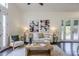 Cozy living room featuring hardwood floors, a neutral sofa, and stylish decor with access to the outdoors at 9444 N 115Th Pl, Scottsdale, AZ 85259