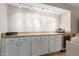 Stylish bar area with granite countertops, wine storage, and custom white cabinetry at 9725 E Mission Ln, Scottsdale, AZ 85258