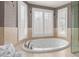 Bathroom showing a soaking tub with jets and views of the dual shuttered windows at 9725 E Mission Ln, Scottsdale, AZ 85258