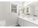 Bathroom featuring a double sink vanity with modern fixtures, decorative mirrors, and a window at 10664 E Emerald Ave, Mesa, AZ 85208