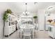 Elegant dining room with a chandelier, white furniture, and a view of the backyard at 10664 E Emerald Ave, Mesa, AZ 85208