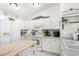 Well-lit kitchen featuring white cabinets, butcher block island, and modern appliances at 10664 E Emerald Ave, Mesa, AZ 85208