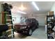 Well-organized garage with vehicle, storage solutions, and overhead lighting at 1185 N Sherwood Way, Queen Valley, AZ 85118