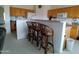 Open kitchen featuring bar-style seating with wicker stools and light wood cabinetry at 1185 N Sherwood Way, Queen Valley, AZ 85118