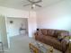 Bright living room features a ceiling fan, neutral carpet, and a comfortable leather couch at 1185 N Sherwood Way, Queen Valley, AZ 85118