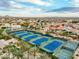 Wide aerial of tennis courts and desert community; a tranquil desert landscape at 11919 E Del Timbre Dr, Scottsdale, AZ 85259