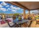 Covered patio with decorative table and chairs overlooks the sparkling pool and water feature at 13102 S 177Th Dr, Goodyear, AZ 85338