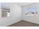 An empty bedroom with carpet and multiple windows at 15397 W Hackamore Dr, Surprise, AZ 85387