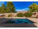 Backyard featuring a swimming pool with rock waterfall amidst lush landscaping, perfect for relaxation at 15788 W Sierra St, Surprise, AZ 85379