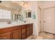 Bright bathroom with double sinks, a large mirror, neutral walls, and tile flooring at 15788 W Sierra St, Surprise, AZ 85379