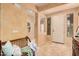 Welcoming foyer with neutral tones, tiled floor, a bench, and ample natural light streaming through windows at 15788 W Sierra St, Surprise, AZ 85379