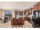 Bright kitchen featuring an island, dark wood cabinetry, stainless steel appliances, and ample counter space at 15788 W Sierra St, Surprise, AZ 85379