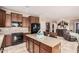 Bright kitchen featuring an island, dark wood cabinetry, stainless steel appliances, and an open floor plan at 15788 W Sierra St, Surprise, AZ 85379