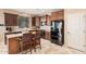 Bright kitchen featuring an island, dark wood cabinetry, stainless steel appliances, and tile flooring at 15788 W Sierra St, Surprise, AZ 85379