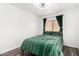 Comfortable bedroom with a patterned green bedspread, window, and hardwood flooring at 16161 W Monte Cristo Ave, Surprise, AZ 85374