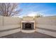 Backyard outdoor fireplace with built in benches and a decorative metal grate at 16161 W Monte Cristo Ave, Surprise, AZ 85374