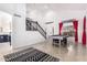 Bright open concept game room and staircase with vaulted ceiling and neutral tile flooring at 16161 W Monte Cristo Ave, Surprise, AZ 85374