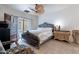 Bedroom with a tufted headboard, neutral bedding, and decorative fan at 16734 E La Montana Dr # 103, Fountain Hills, AZ 85268