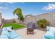 The backyard patio features artificial grass, cozy seating, a grill, and a desert landscape at 18248 W Carlota Ln, Surprise, AZ 85387