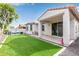 Charming backyard featuring lush turf, a covered patio, and ample space for outdoor activities and relaxation at 18248 W Carlota Ln, Surprise, AZ 85387