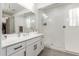 All-white bathroom features a glass shower, large vanity and modern fixtures at 18248 W Carlota Ln, Surprise, AZ 85387