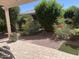 Charming backyard with a covered patio, gravel and stone landscaping, as well as flowering bushes for a relaxing outdoor experience at 20194 N Riverbank Rd, Maricopa, AZ 85138