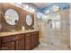 Bright bathroom showcasing double vanity, granite countertops, and a glass-enclosed shower with tiled surround at 20194 N Riverbank Rd, Maricopa, AZ 85138