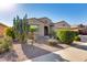 Single-story home featuring desert landscaping, a two-car garage, and covered front entry at 20194 N Riverbank Rd, Maricopa, AZ 85138