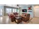 Inviting living room featuring comfortable leather seating, a ceiling fan, and bright windows at 20194 N Riverbank Rd, Maricopa, AZ 85138