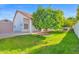 Lush backyard with an orange tree and green grass with white exterior accents and ample space at 2020 E Norwood St, Mesa, AZ 85213