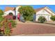 Inviting home exterior showcasing a vibrant red front door, lush greenery, and well-maintained landscaping at 2020 E Norwood St, Mesa, AZ 85213