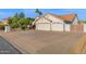 Spacious three-car garage with a long driveway and mature landscaping enhancing the curb appeal at 2020 E Norwood St, Mesa, AZ 85213