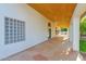 Inviting covered patio features a tiled floor, wood ceiling, and decorative glass block window for added appeal at 2020 E Norwood St, Mesa, AZ 85213