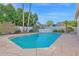 Inviting pool featuring a waterfall feature and bordered by tropical trees with a stone tile surround at 2020 E Norwood St, Mesa, AZ 85213