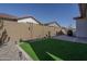 Private backyard featuring low-maintenance landscaping and artificial turf at 20392 W Brittlewood Ave, Buckeye, AZ 85396