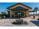 Clubhouse entrance featuring a modern fountain, desert landscaping, and a covered entryway with large glass doors at 20392 W Brittlewood Ave, Buckeye, AZ 85396