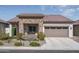 Charming single-Gathering home featuring a stone facade, desert landscaping, and an attached two-car garage at 20392 W Brittlewood Ave, Buckeye, AZ 85396