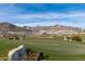 Golf course with lush green fairways, desert landscaping, and mountain views in the background at 20392 W Brittlewood Ave, Buckeye, AZ 85396