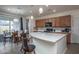 Bright kitchen featuring an island with seating, pendant lighting, and open to the dining area at 20392 W Brittlewood Ave, Buckeye, AZ 85396