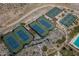 Aerial view of the community tennis courts featuring blue courts, desert landscaping, and covered seating areas at 20392 W Brittlewood Ave, Buckeye, AZ 85396