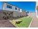 Backyard featuring artificial turf, a cornhole game, and a stylish fence with potted plants at 2180 N Iowa St, Chandler, AZ 85225