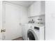 Convenient laundry room equipped with a washer, dryer, and overhead cabinet storage at 2421 E Del Rio Dr, Tempe, AZ 85282