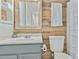 Charming bathroom with wood plank accent wall, gray vanity, and decorative mirror at 2701 E Hobart St, Gilbert, AZ 85296