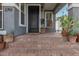 Close-up of a charming front porch with hanging chair, stucco walls, brick steps and potted plants at 2701 E Hobart St, Gilbert, AZ 85296