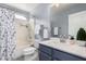 Bathroom with tiled shower and tub combo, sink with blue cabinets, and large mirror at 2704 E Anderson Dr, Phoenix, AZ 85032