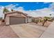 Exterior view of home featuring a desert landscape, a concrete driveway, and an attached two-car garage at 2704 E Anderson Dr, Phoenix, AZ 85032