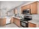 Well-lit kitchen featuring stainless steel appliances, wooden cabinets, and a tile floor at 2704 E Anderson Dr, Phoenix, AZ 85032