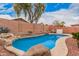 Backyard featuring private pool surrounded by rock and desert landscaping at 2704 E Anderson Dr, Phoenix, AZ 85032